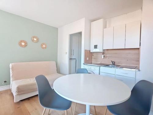 a kitchen with a white table and chairs in a room at T2 vue mer accès direct plage le barcares in Le Barcarès