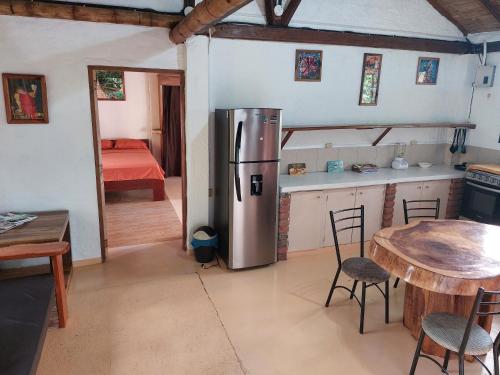 a kitchen with a stainless steel refrigerator and a table at Casa Ariana, Acepto Mascota in Ayampe