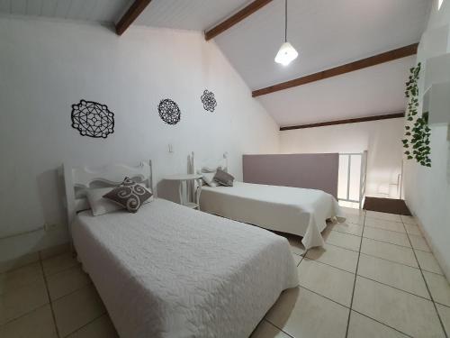 a bedroom with two beds and a table in it at Pousada Ventos de Outono in São Roque