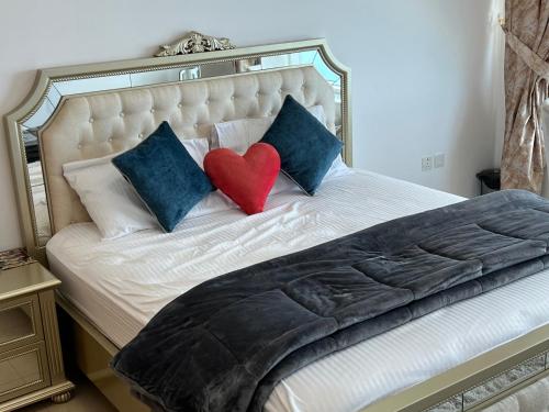 a bed with two pillows with a red heart on it at F30,R3,Sunrise on the beach,1room inside 3bedroom apartment,(separate washroom outside) in Ajman 