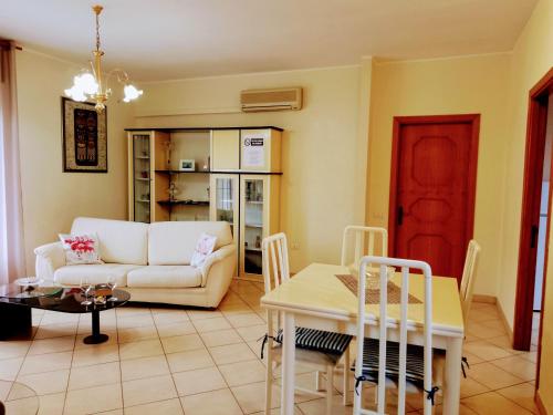 ein Wohnzimmer mit einem Sofa und einem Tisch in der Unterkunft Il Fenicottero Rosa Casa Sanzio in Quartu SantʼElena