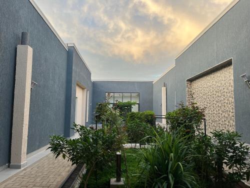 uma vista exterior de uma casa com paredes e plantas azuis em Eliora Hotel, Tororo em Tororo