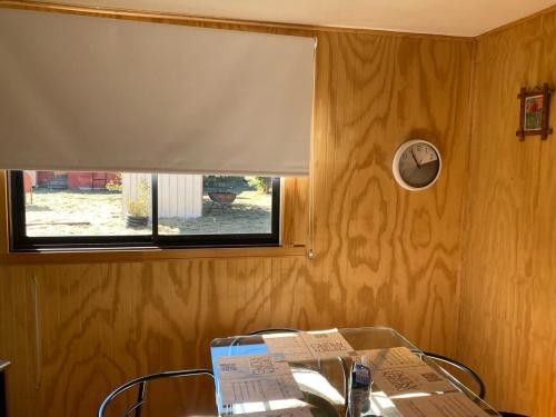 a glass table with a window and a window blind at Cabañas Captren Andino in Curacautín