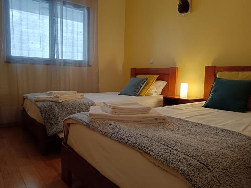 Dos camas en una habitación con toallas. en Casa da Vila, en Santa Cruz