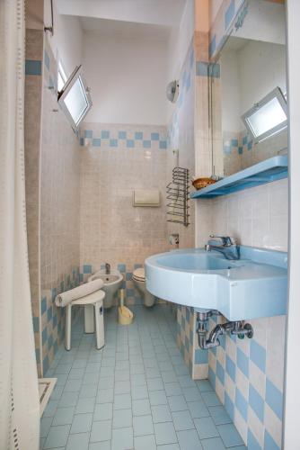 a blue and white bathroom with a tub and a sink at Hotel San Paolo in Rimini