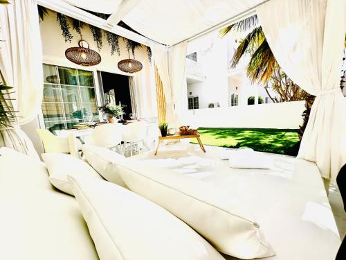 a living room with white furniture and a large window at Luxury villa Fanabe with private garden in Adeje