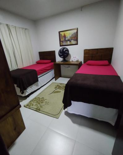 1 dormitorio con 2 camas y alfombra en Condomínio Sonhos Da Serra, en Bananeiras