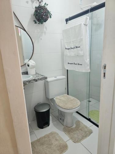 a bathroom with a toilet and a glass shower at Marques Beach House in Marechal Deodoro