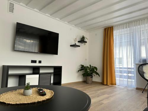 ein Wohnzimmer mit einem Tisch und einem TV an der Wand in der Unterkunft Apart7 in Lermoos