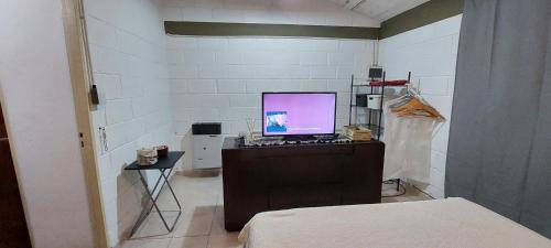 een kamer met een computer op een bureau met een bed bij Habitación En La Casita de Marley in Villa Carlos Paz