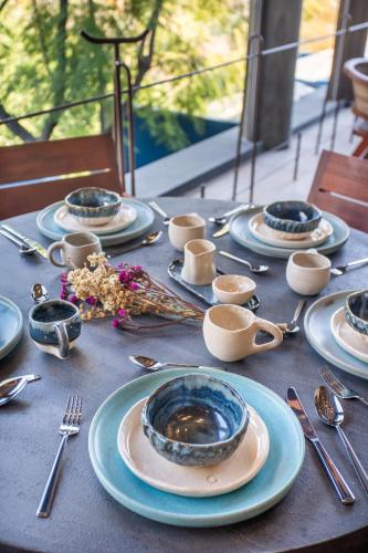 a table with blue and white plates and silverware at Casa Cristina Fresh Boutique Hotel in Cuernavaca