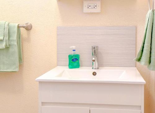 a bathroom sink with a bottle of soap on it at Apartment 6, Kenridge Residences, West coast in Saint James