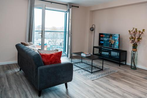 a living room with a couch and a tv at Entire 2 Bedroom and 2 Bathroom Apartment in Manchester City -Free underground Parking in Manchester