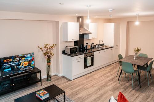 a kitchen and living room with a table and a tv at Entire 2 Bedroom and 2 Bathroom Apartment in Manchester City -Free underground Parking in Manchester