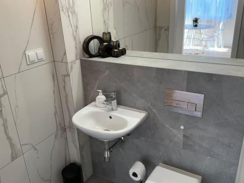 a bathroom with a sink and a toilet and a mirror at Glamour Apartment in Ochota in Warsaw
