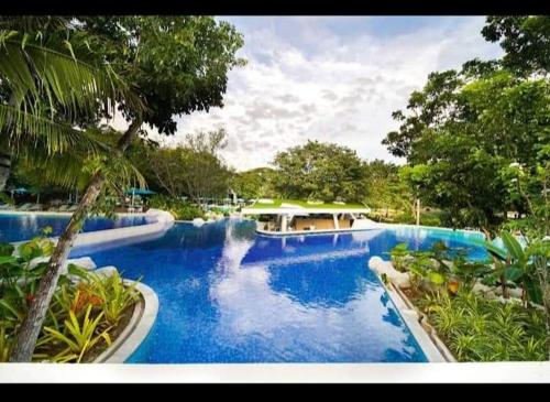 a swimming pool with a waterfall in a resort at Tambuli maribago seaside living and resort in Lapu Lapu City