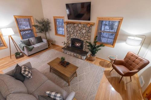 ein Wohnzimmer mit einem Sofa und einem Kamin in der Unterkunft River Rock Chalet :: Hot Tub, Pets, Stevens Pass in Skykomish