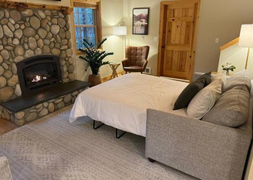 a bedroom with a large bed and a fireplace at River Rock Chalet :: Hot Tub, Pets, Stevens Pass in Skykomish