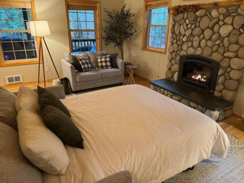 a bedroom with a large bed and a fireplace at River Rock Chalet :: Hot Tub, Pets, Stevens Pass in Skykomish