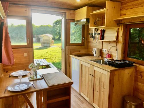 a kitchen with a counter and a sink in a tiny house at Vue Poneys, 40min Mt St Michel 30min Mer Draps Serviettes Baie Normandie Cottage in La Chapelle-Cécelin