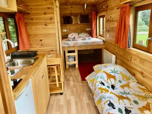 a small room with a bed in a tiny house at Vue Poneys, 40min Mt St Michel 30min Mer Draps Serviettes Baie Normandie Cottage in La Chapelle-Cécelin