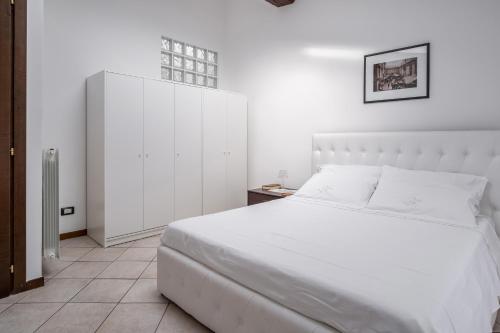 Alzano Lombardo的住宿－La Vecchia Filanda 4 - Alzano Lombardo - by Host4U，白色卧室配有白色的床和橱柜