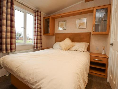 a bedroom with a large bed with a window at Larenzo in Preston