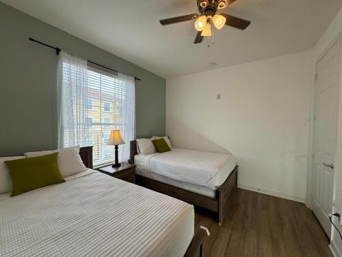 1 Schlafzimmer mit 2 Betten und einem Deckenventilator in der Unterkunft Vista Cay Getaway Luxury Condo by Universal Orlando Rental in Orlando