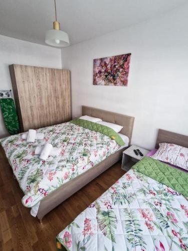 two beds sitting next to each other in a room at Tuse Lux apartments in Skopje