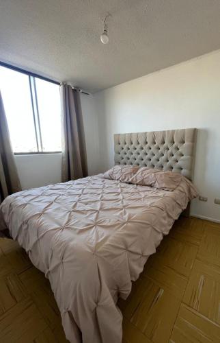 a large bed in a bedroom with a large window at Apartamento amoblado 338 Ovalle in Ovalle