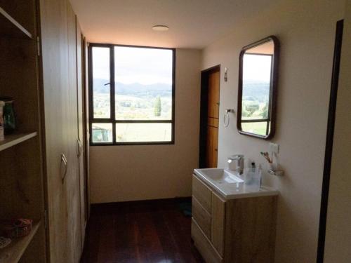 ein Badezimmer mit einem Waschbecken und zwei Fenstern in der Unterkunft Finca El Ciprés in Tuta