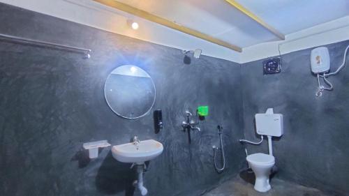 a bathroom with a sink and a toilet and a mirror at Svabodha Wellness in Parxem