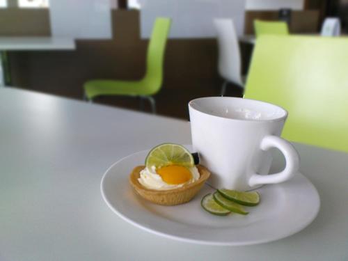 a cup of coffee and a pastry with an egg and lime at The LimeTree Hotel, Kuching in Kuching