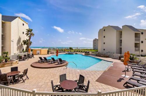 a swimming pool with chairs and a table and a patio at Luxury Beachfront Condo with Private Pool &Terrace in South Padre Island