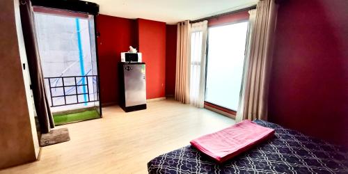 a bedroom with red walls and a bed and two windows at Hash Silom Apartment @ Silom Soi 3 in Bangkok