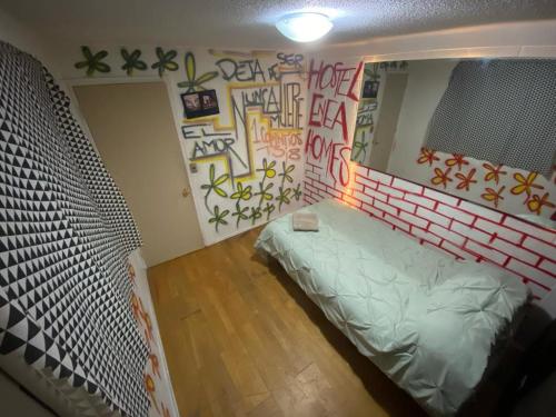 um quarto com uma cama e graffiti na parede em Hostel Enea Homes em Santiago