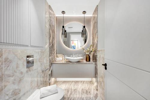 a bathroom with a sink and a mirror at Arcore Premium Apartments Regent Park in London