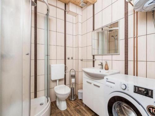 a bathroom with a toilet a sink and a washing machine at Apartments with parking space Rudanovac, Plitvice - 20767 in Korenica