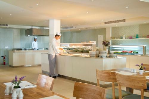 two chefs preparing food in a restaurant kitchen at Pernera Beach Hotel in Protaras