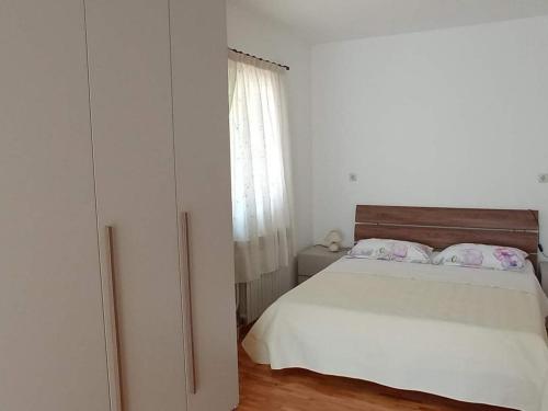 een witte slaapkamer met een bed en een raam bij Apartments with a parking space Rovinj - 22527 in Rovinj