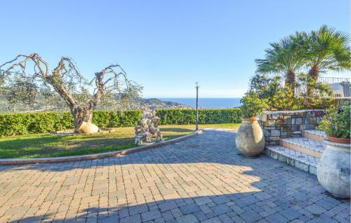 a patio with three large vases in a park at Nice Home In Imperia With Wifi in Imperia