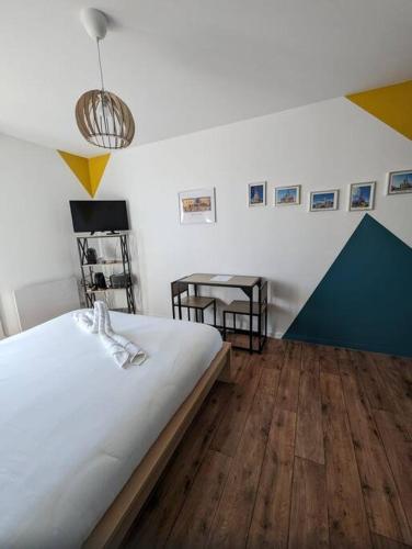 - une chambre avec un lit blanc, une table et des chaises dans l'établissement Disney’s Gallery à 5 minutes de Disneyland Paris, à Montévrain