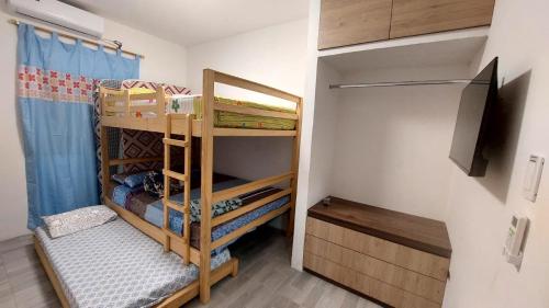 Cette petite chambre dispose de lits superposés et d'une télévision. dans l'établissement Hospedaje Casa San Pablo, à Santa Elena