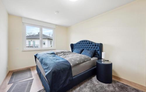 a bedroom with a blue bed and a window at Gorgeous Home In Hennigsdorf With Lake View in Hennigsdorf