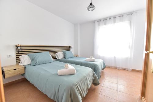 dos camas sentadas una al lado de la otra en un dormitorio en New Premium Apartment - Free Parking & Pools en La Algaba