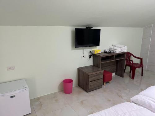 a room with a bed and a desk with a television at Sky south in Xiaoliuqiu