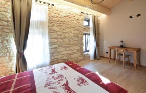 a bedroom with a bed and a stone wall at Gorgeous Apartment In Velo Veronese With House A Panoramic View in Velo Veronese