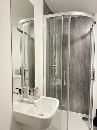 a white bathroom with a sink and a shower at Stylish Central Escape in Sheffield