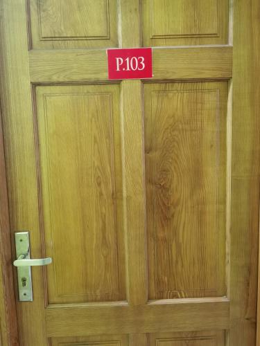 una puerta de madera con una señal rosa en ella en MOTEL WIN PHÁT, en Bien Hoa