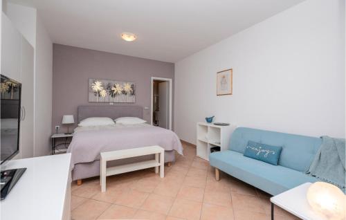 ein Schlafzimmer mit einem Bett und einem blauen Sofa in der Unterkunft Nice Apartment In Baska Voda With Kitchen in Baška Voda